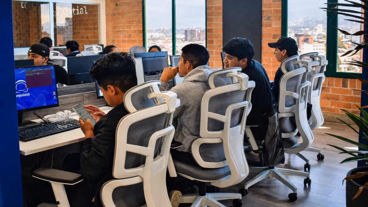 Campers de Campuslands Guatemala colaborando frente a sus computadores en Campus Tec