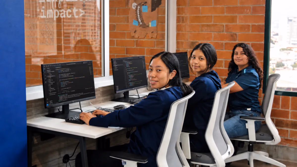 Tres campers de Campuslands Guatemala practicando programación en el aula de Campus Tec