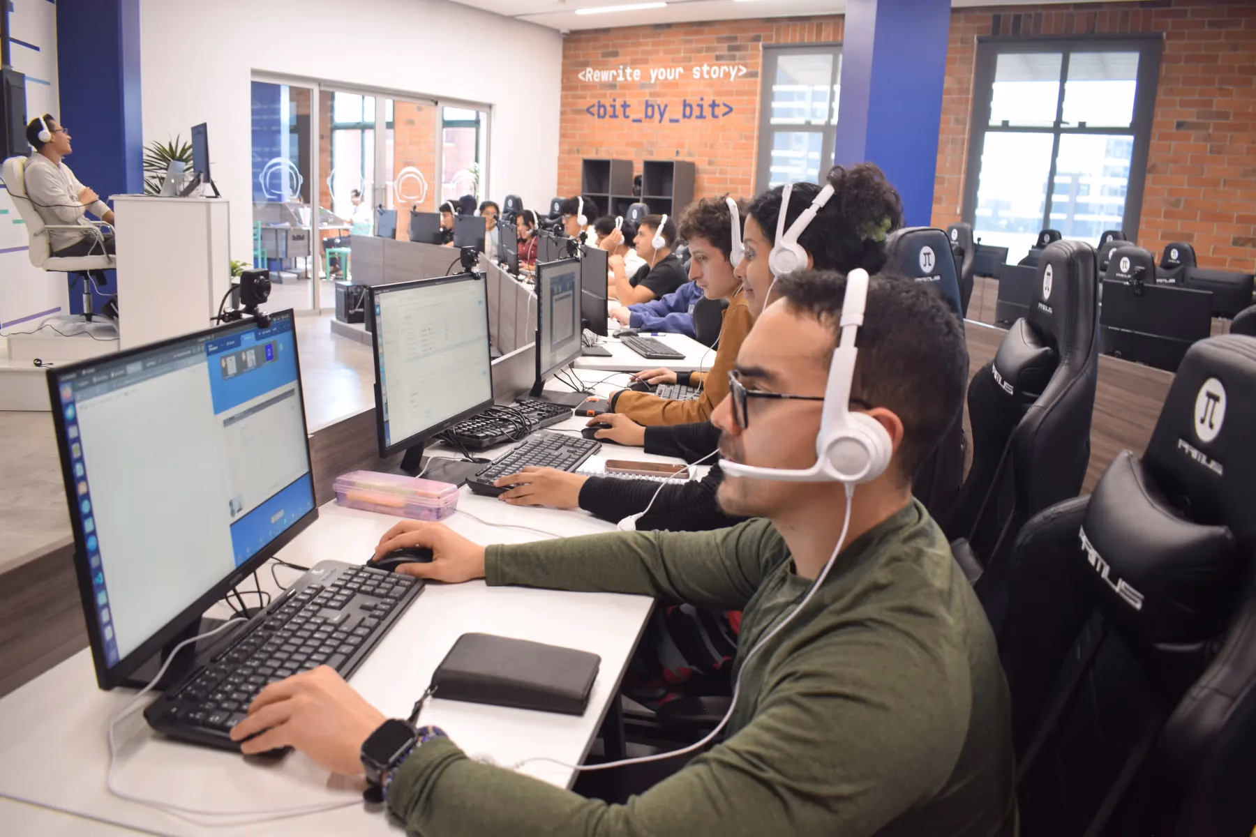 Campers de Campuslands trabajando en desarrollo de software en un aula tecnológica